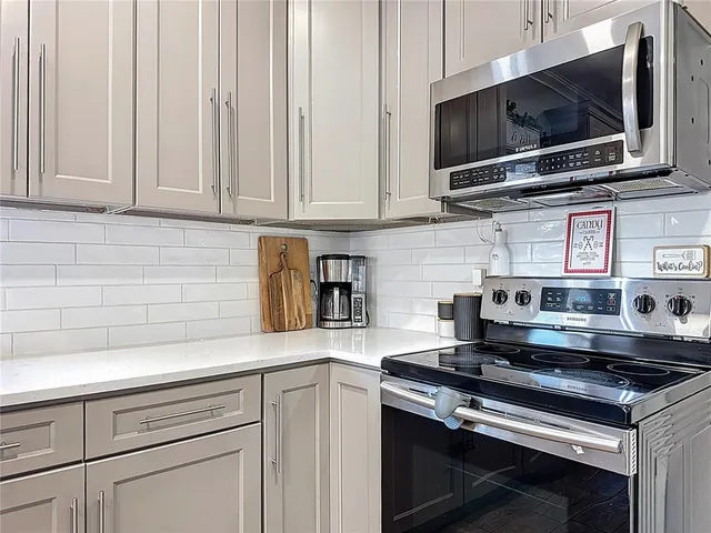 a kitchen with stainless steel appliances white cabinets and a stove top oven