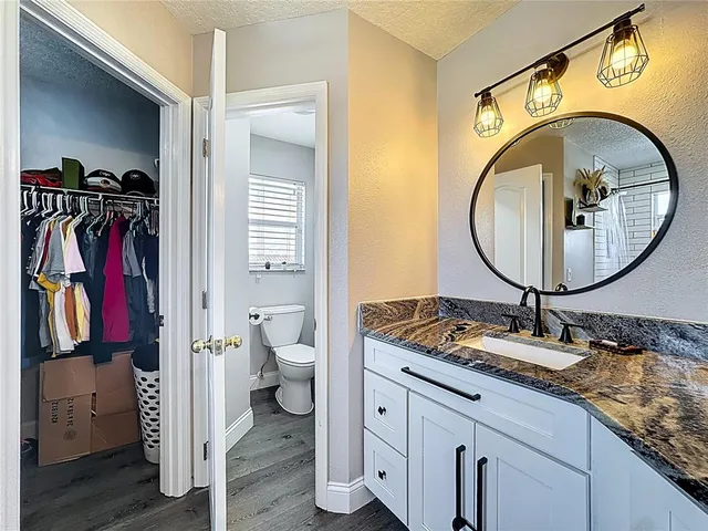 a bathroom with a granite countertop toilet sink and a mirror