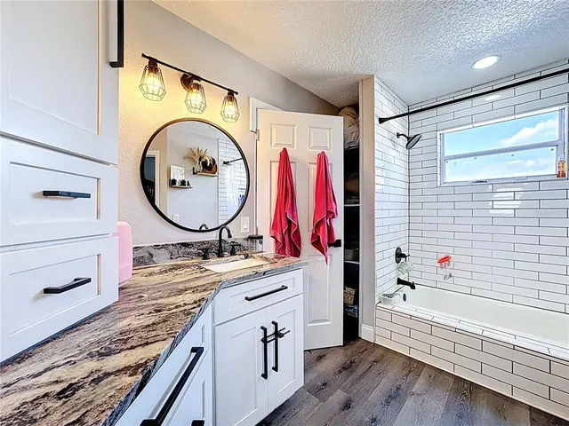 a bathroom with a granite countertop sink and a mirror