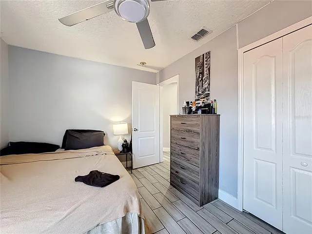 a bedroom with a bed and wooden floor