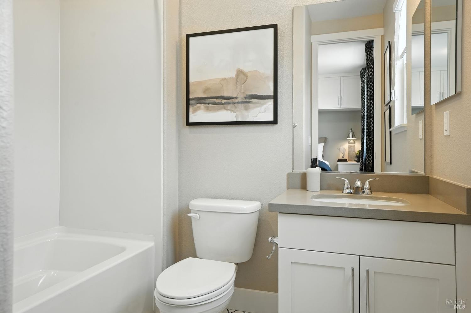 104 Cardamom Lane, Unit 1103 Morgan Hill, CA 95037 - Photo 14 of 19 a bathroom with a granite countertop toilet a sink and a mirror