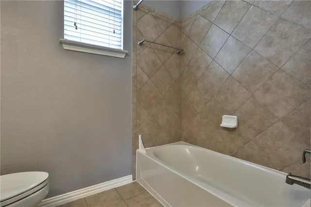 a bathroom with a white bath tub and a window