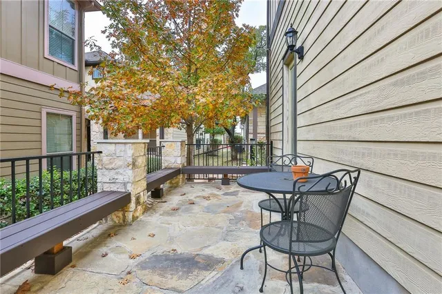 a view of a patio with table and chairs and wooden fence