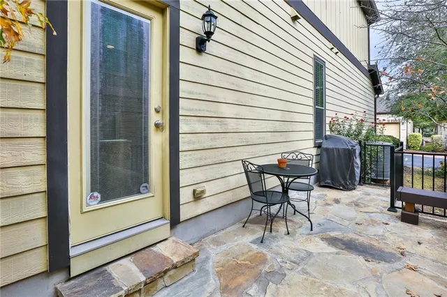 a view of a patio with table and chairs and wooden fence
