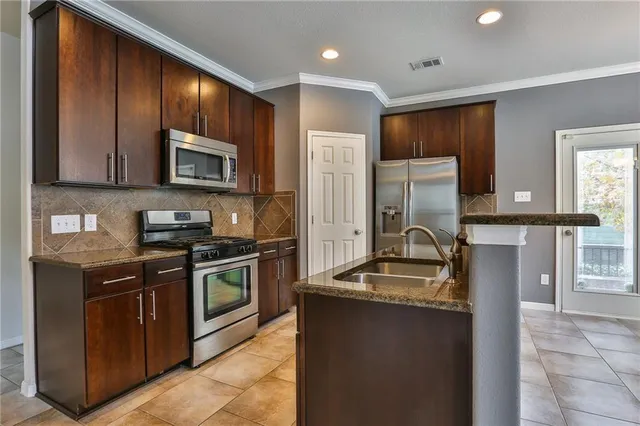 a kitchen with granite countertop stainless steel appliances and wooden cabinets
