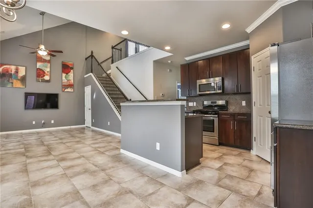 a kitchen with granite countertop a refrigerator and a stove top oven