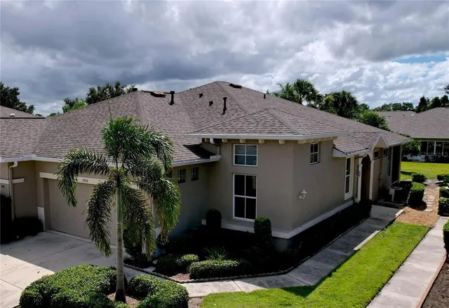 a view of a house with backyard and trees