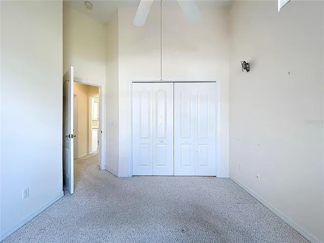 an empty room with windows and ceiling fan