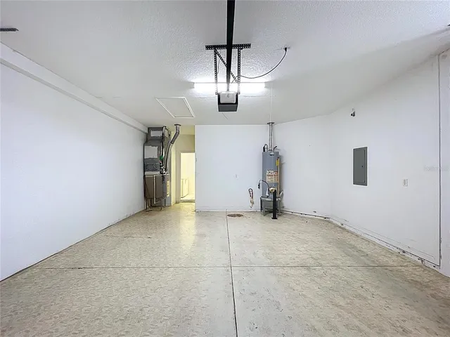 a couple of table and chairs under an umbrella in front of yellow house