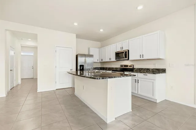 a kitchen with stainless steel appliances granite countertop a refrigerator and a stove top oven