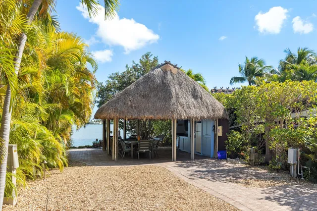 a patio with table and chairs under an umbrella