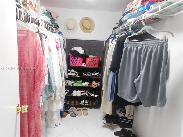 a view of walk in closet with clothes and shoes
