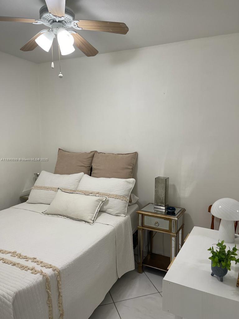 5005 Collins Avenue, Unit 322 Miami Beach, FL 33140 - Photo 11 of 15 a bedroom with a bed and a chandelier