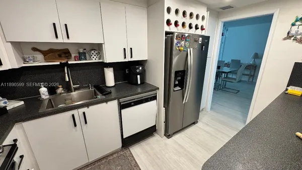a kitchen with stainless steel appliances granite countertop a refrigerator and a sink