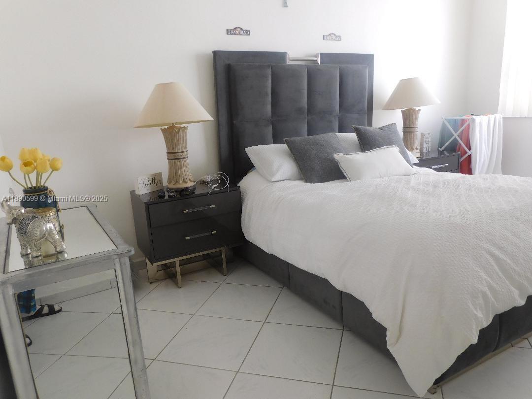 5005 Collins Avenue, Unit 322 Miami Beach, FL 33140 - Photo 7 of 15 a bedroom with a bed and a lamp