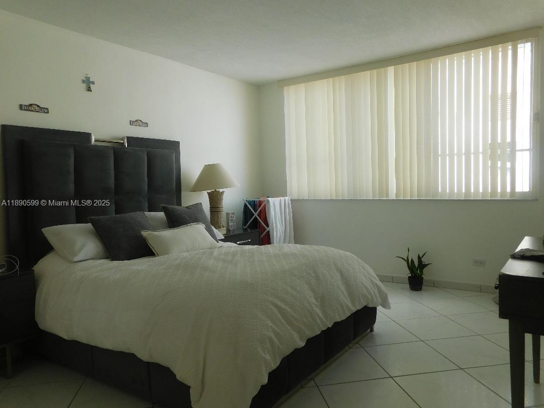 5005 Collins Avenue, Unit 322 Miami Beach, FL 33140 - Photo 8 of 15 a bedroom with a bed and furniture