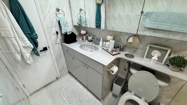 a bathroom with a sink and mirror with bathtub