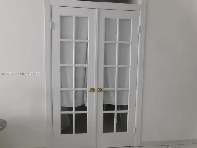 a view of an empty room with wooden floor and closet