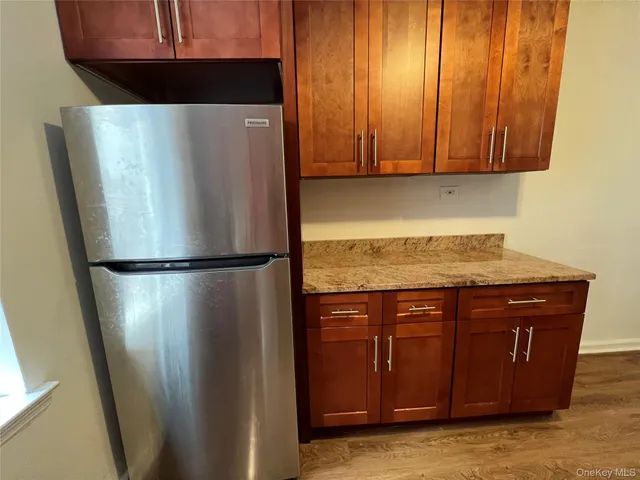 a view of a refrigerator in kitchen with stainless steel appliances granite countertop cabinets and a refrigerator