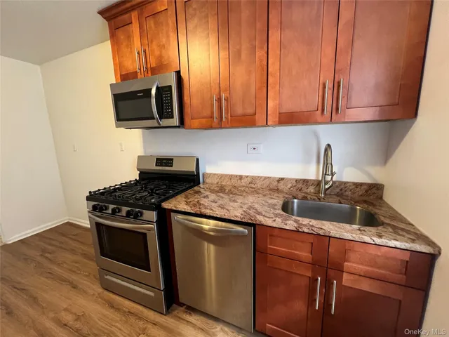 a kitchen with granite countertop wooden cabinets and a stove top oven