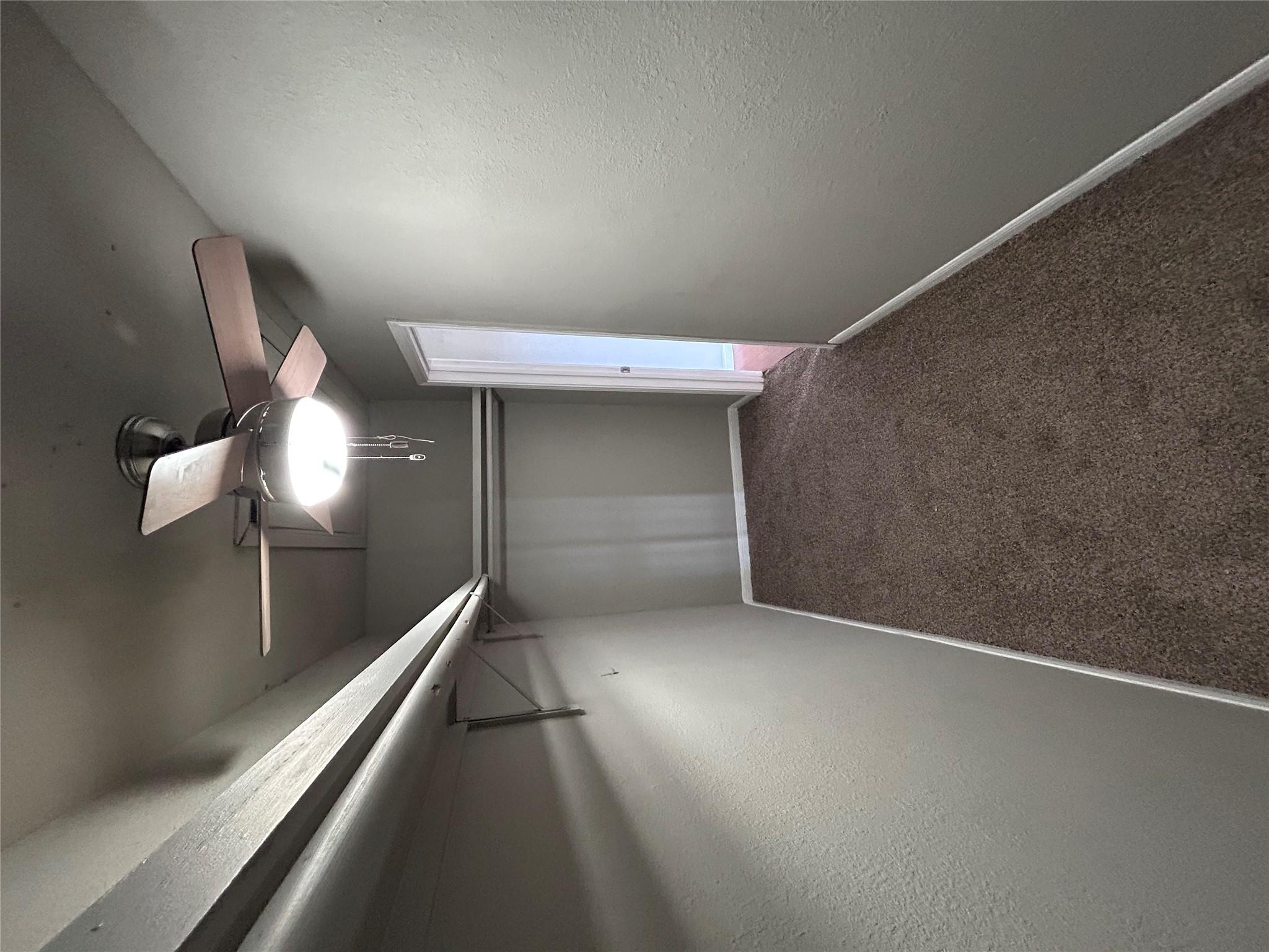 5708 Spring Meadow Road, Unit B Austin, TX 78744 - Photo 12 of 23 Walk in closet with dark colored carpet and ceiling fan