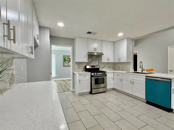 a kitchen with granite countertop stainless steel appliances cabinets a sink and a counter top space
