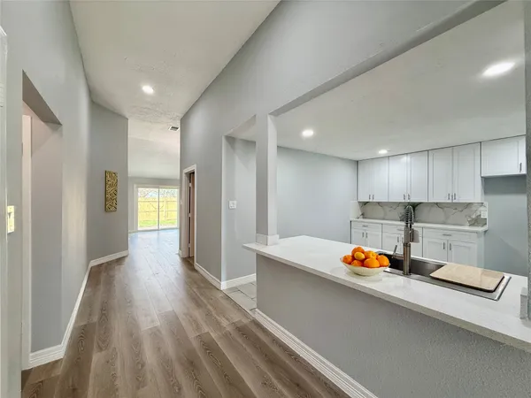 a view of a kitchen with wooden floor and electronic appliances