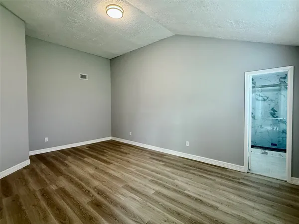 a view of an empty room and wooden floor