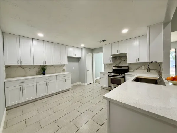 a kitchen with granite countertop white cabinets white stainless steel appliances with a sink and dishwasher