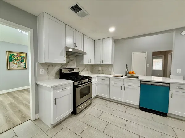 a kitchen with granite countertop cabinets stainless steel appliances and a counter space