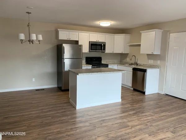 a kitchen with stainless steel appliances granite countertop a refrigerator a stove a sink and a microwave