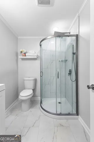 a bathroom with a toilet and a shower