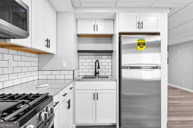 a kitchen with stainless steel appliances granite countertop a sink and a stove