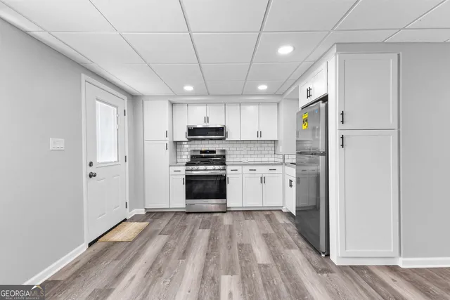 a kitchen with white cabinets and stainless steel appliances