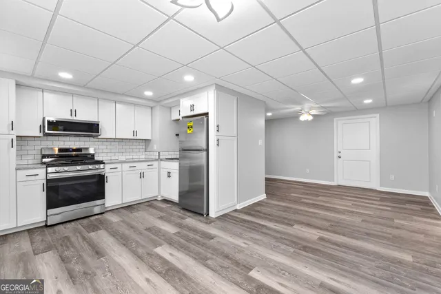 a kitchen with stainless steel appliances kitchen island granite countertop a refrigerator and a stove top oven