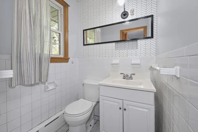 a bathroom with a toilet a sink and mirror