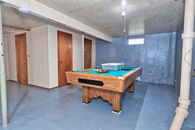wooden room with pool table and windows