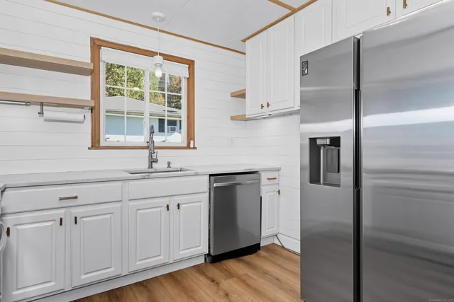 a kitchen with white cabinets and a refrigerator