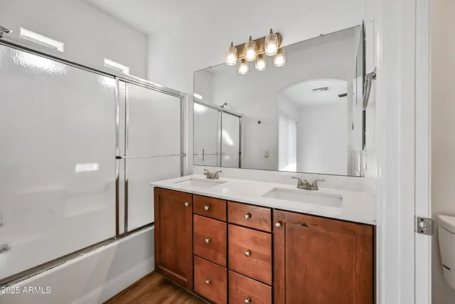 a bathroom with a double vanity sink mirror and shower