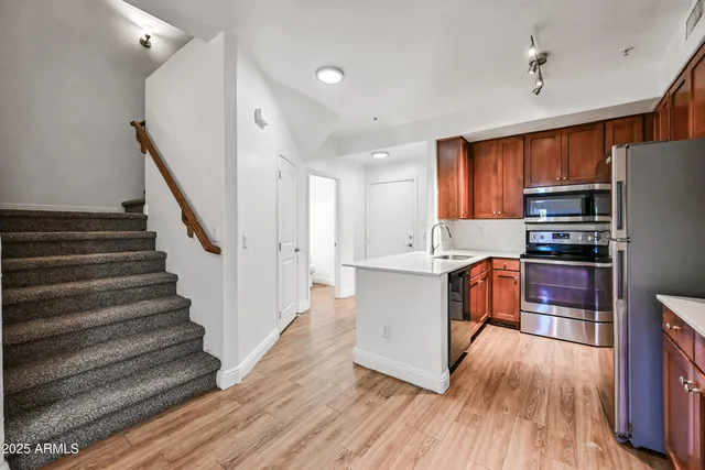 a kitchen with wooden floors and wooden cabinets