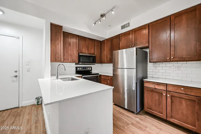 a kitchen with stainless steel appliances a refrigerator stove microwave and sink
