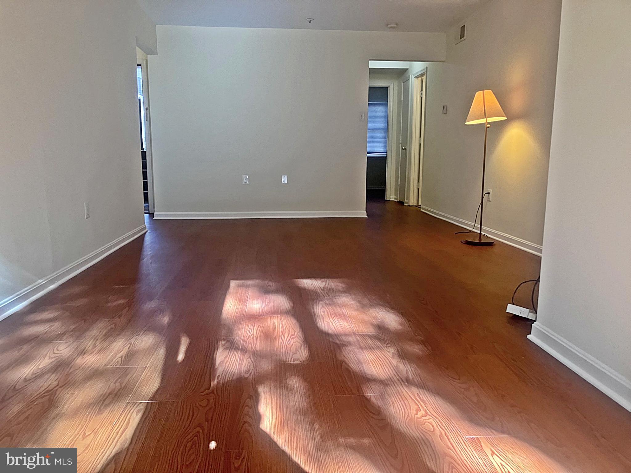 an empty room with wooden floor and bathroom