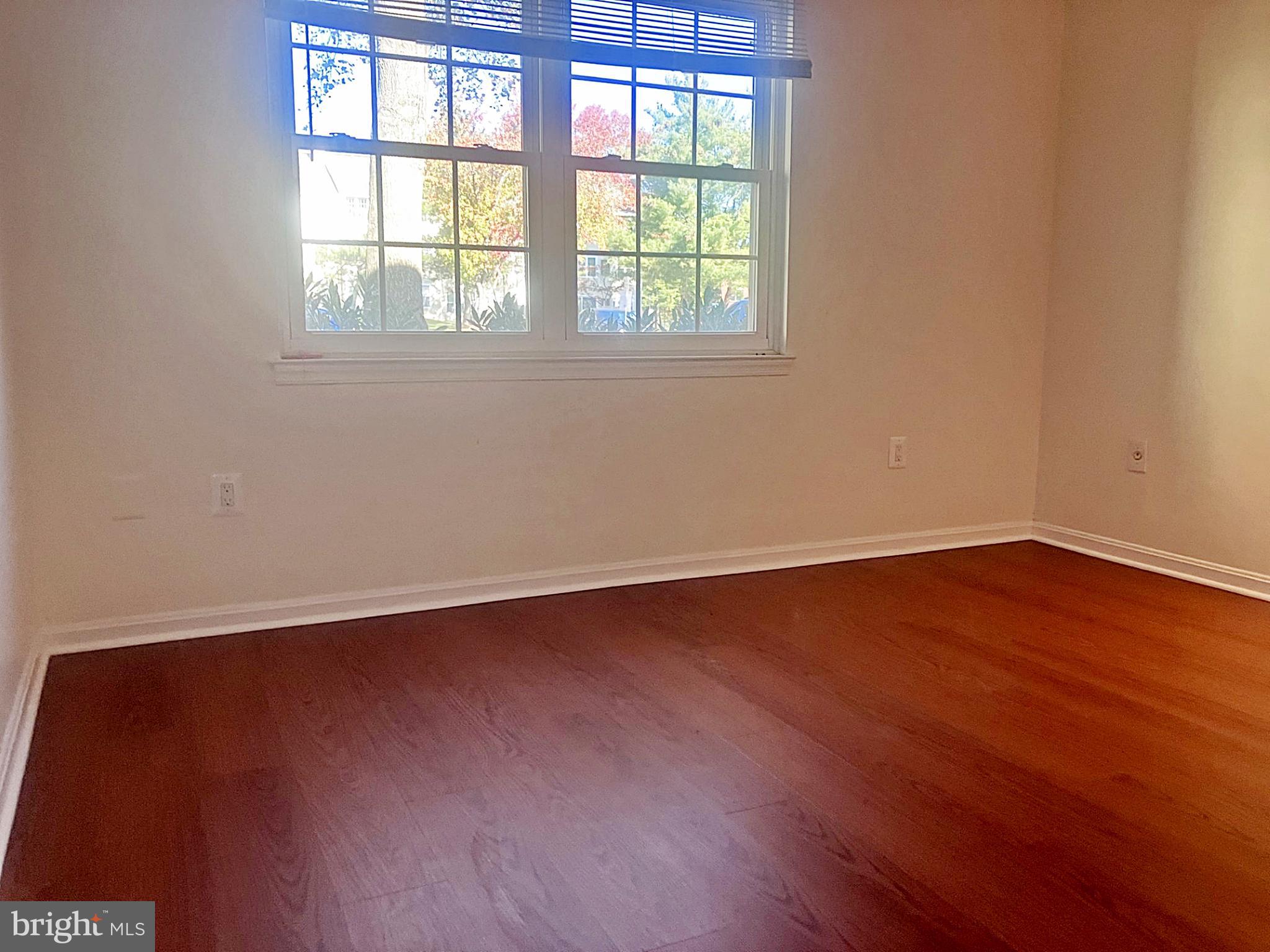 14909 Cleese Court, Unit 4CA Silver Spring, MD 20906 - Photo 21 of 43 an empty room with wooden floor and windows