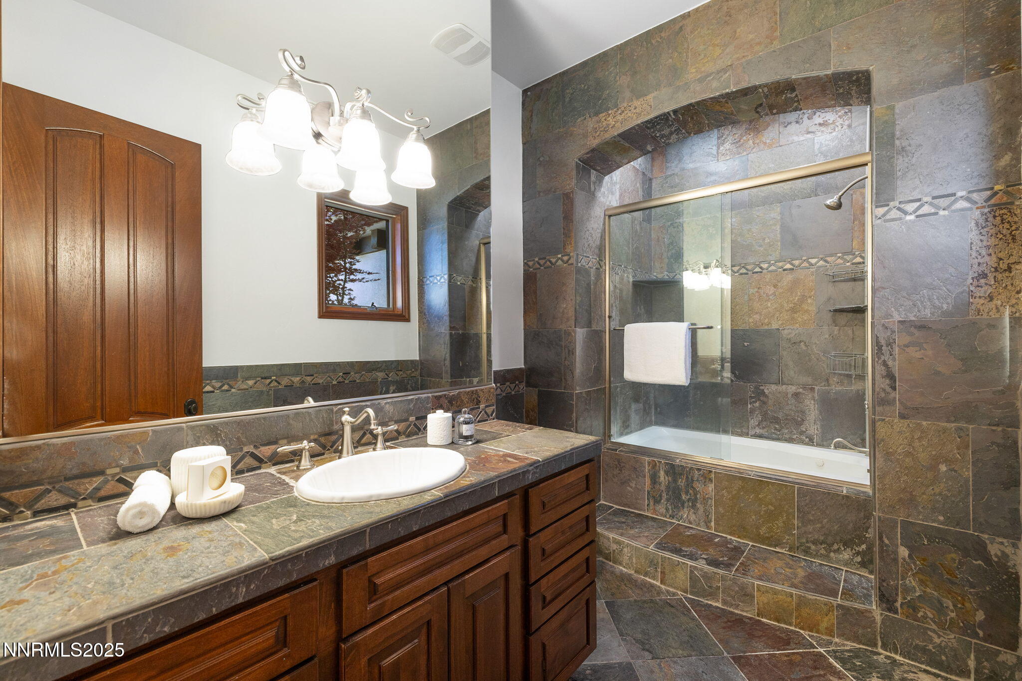 12900 Silver Wolf Road Reno, NV 89511 - Photo 14 of 51 a bathroom with a granite countertop sink a mirror and a shower