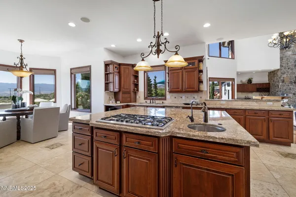 a large kitchen with stainless steel appliances kitchen island granite countertop a large counter top and a stove top oven