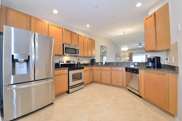 a kitchen with granite countertop white cabinets and stainless steel appliances