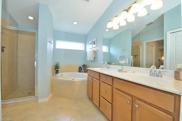 a spacious bathroom with a tub sink and mirror