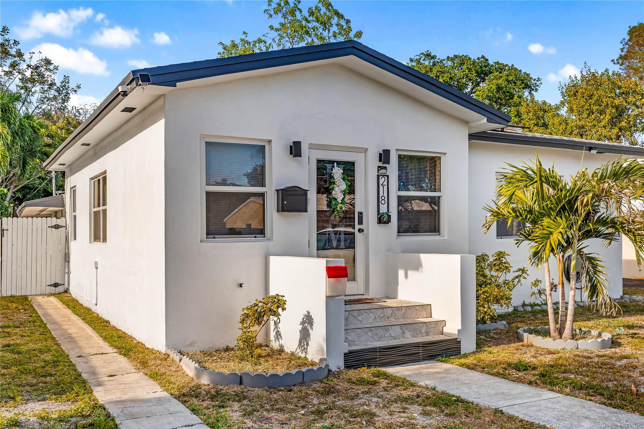 218 Southwest 7th Street Dania Beach, FL 33004 - Photo 1 of 57 a front view of a house with garden