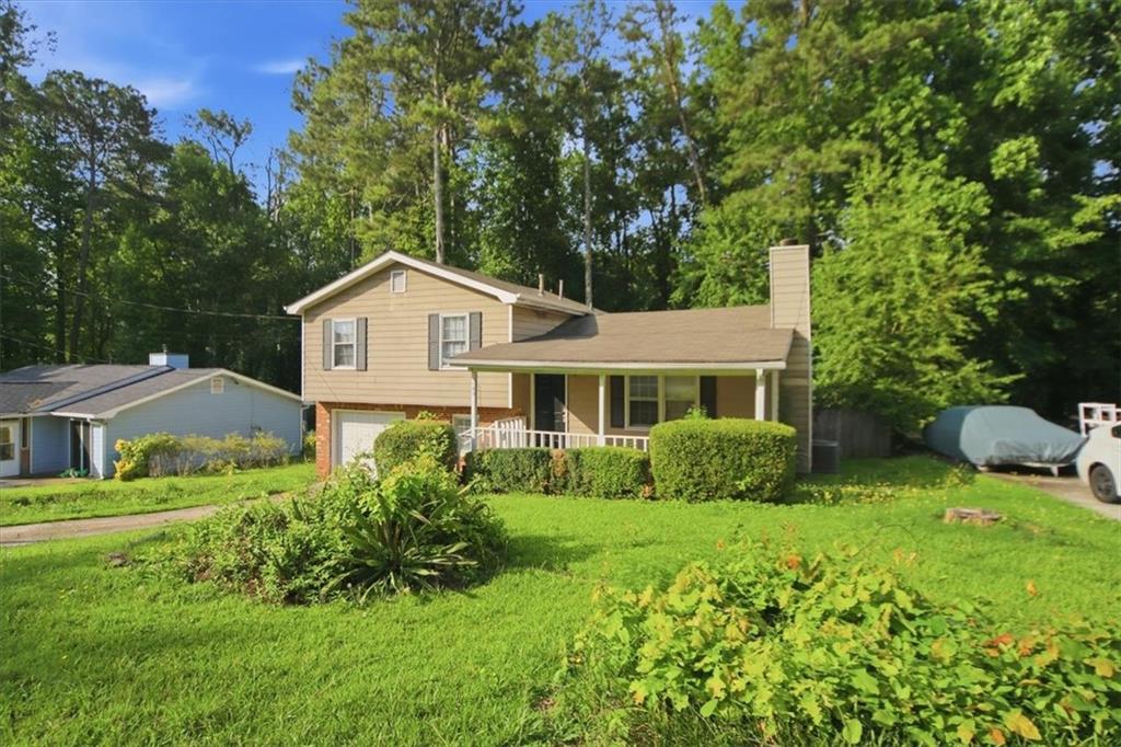 1496 Cherry Hill Road Southwest Conyers, GA 30094 - Photo 27 of 32 a front view of a house with garden and trees