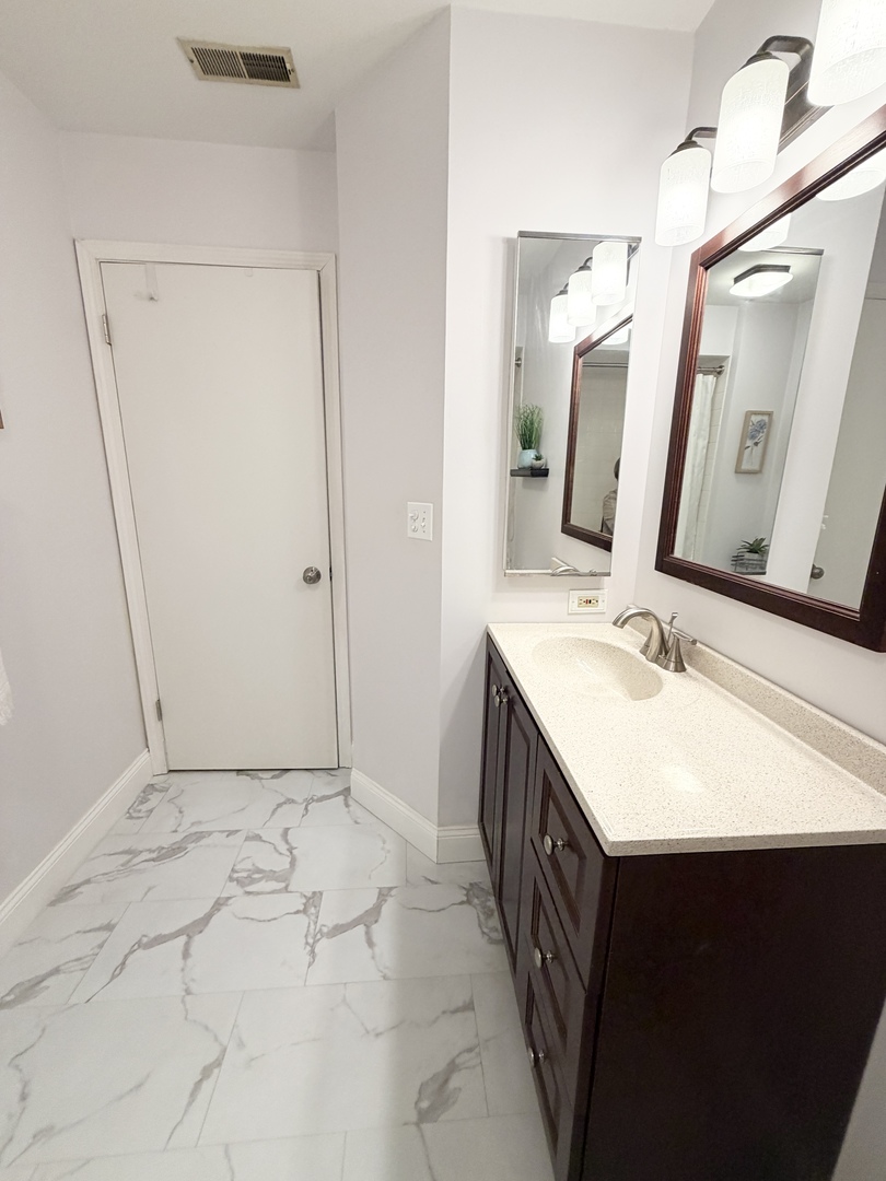 300 East Dundee Road, Unit 102A Buffalo Grove, IL 60089 - Photo 22 of 27 a bathroom with a double vanity sink and mirror